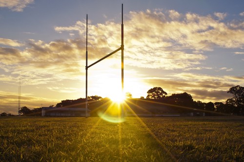 Field with goal posts and sunset
